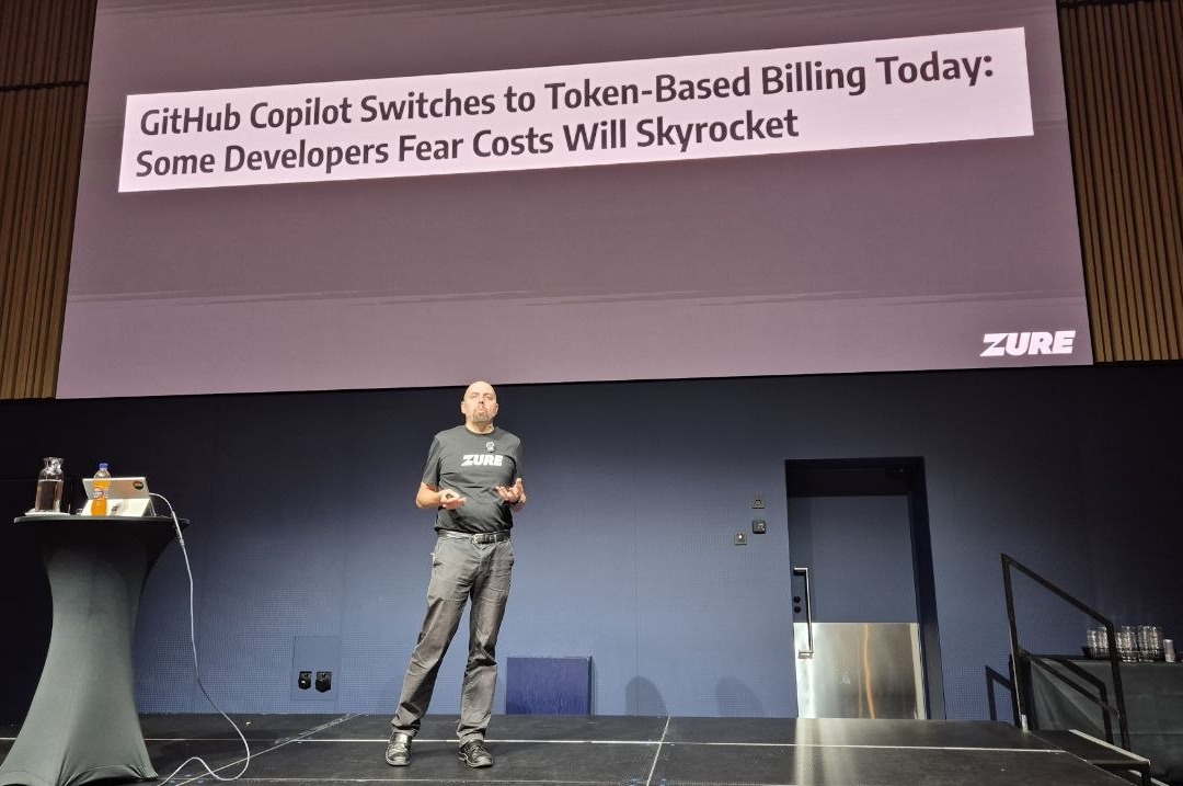 Jouni Heikniemi in front of a news headline slide: GitHub Copilot switches to token-based billing today, some developers fear costs will skyrocket