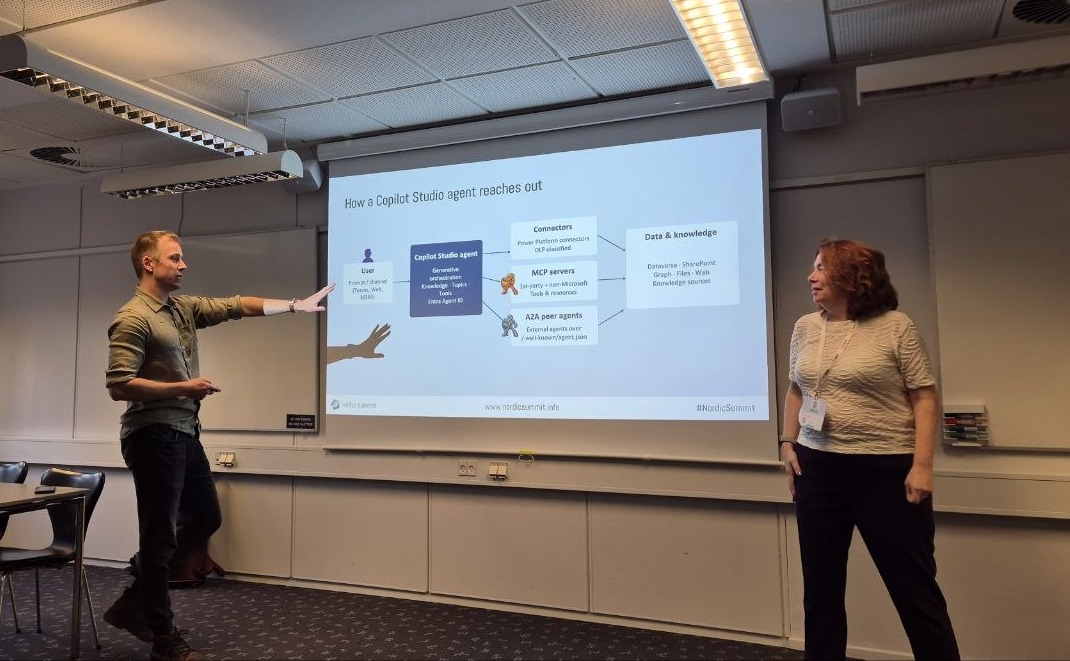 Tatu Seppälä pointing at the slide How a Copilot Studio agent reaches out: connectors, MCP servers, A2A peer agents and data and knowledge, with Claire Edgson listening