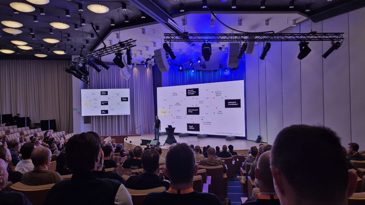 The auditorium at Experts Live Sweden 2026 during Sami Laiho's keynote, with the ransomware ecosystem slide on both screens
